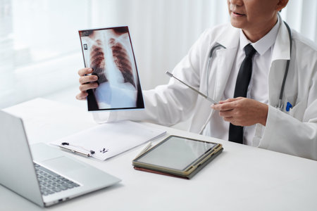 Cropped image of general practitioner pointing at lungs xray when having telemedicine session with...