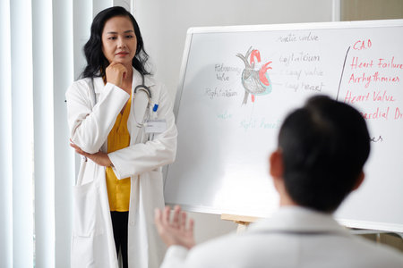 Pensive cardiologist listening to coworker speaking in meeting on common disease treatment