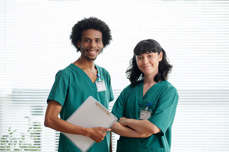 Portrait of medical nurses in green scrubs smiling at cameraの写真素材