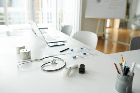 Contactless thermometer, oxymeter and stethoscope on desk of general practitioner