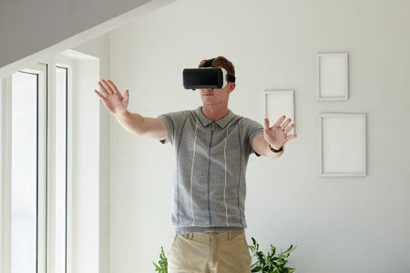 Young man playing video game in virtual reality headset