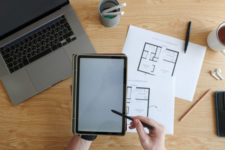 Hands of young man drawing apartment design project on tablet computer
