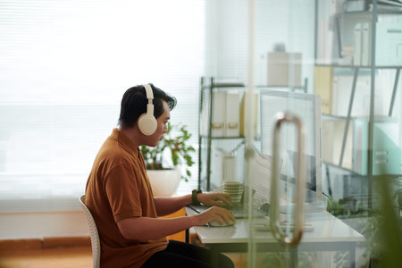 Young man with disability working on computer in his home office