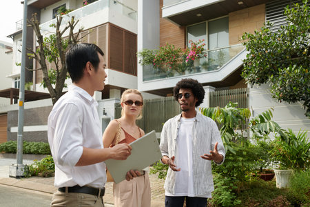Real estate agent meeting with young couple to show them houses in new district