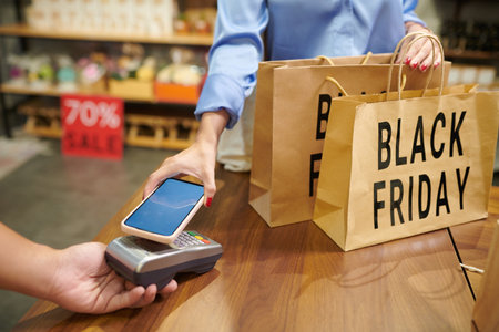 Customer paying for purchases with mobile application when shopping on Black Fridayの写真素材