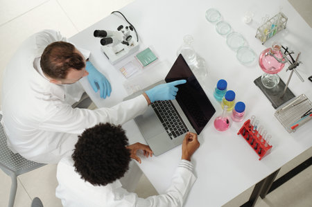 Team of chemists discussing results of laboratory research, view from aboveの写真素材