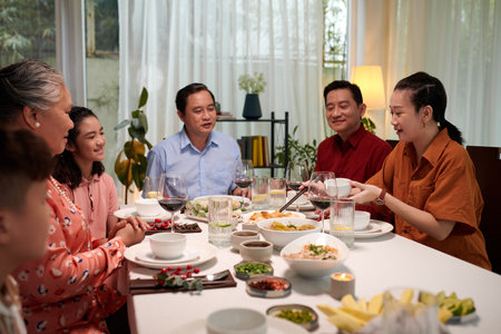 Big Vietnamese family eating traditional dishes at family celebrationの写真素材