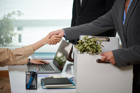 Cropped image of promoted young businesswoman shaking hand of new coworkerの写真素材
