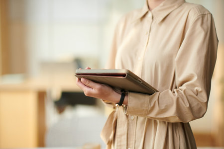 Cropped image of young businesswoman working on tablet computerの写真素材
