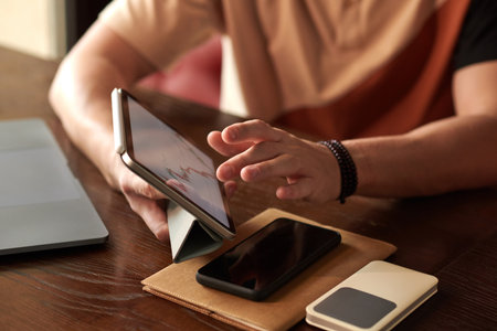 Trader analyzing statistics on tablet computer when working on trading planの写真素材