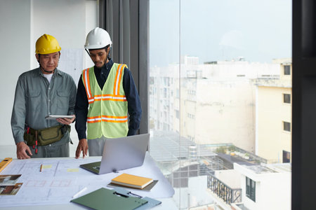 Team of construction workers having video call with foreman