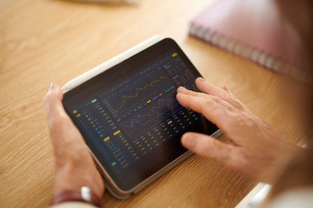 Closeup image of businesswoman analyzing trading data on tablet screenの写真素材