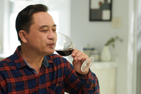 Portrait of senior man enjoying good wine when having dinner