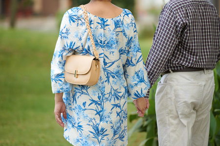 Senior couple holding hands when walking in city park, enjoying romantic date