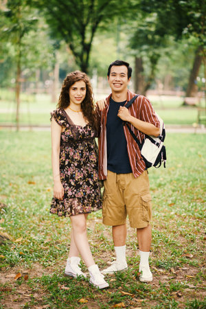 Portrait of happy diverse young couple walking in park