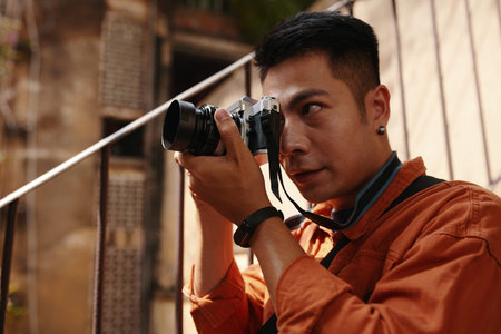 Focused professional photographer taking photos in old decaying building