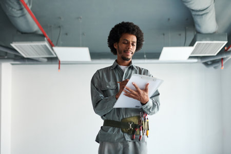 Portrait of foreman inspecting construction site and taking notes in documentの写真素材