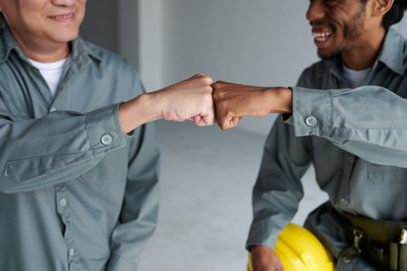 Positive construction engineers making fist bump after finishing day at workの写真素材