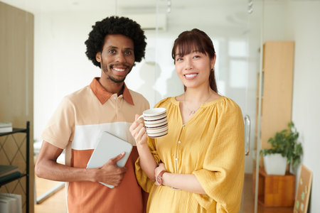 Portrait of cheerful colleagues with coffee cup and tablet computerの写真素材