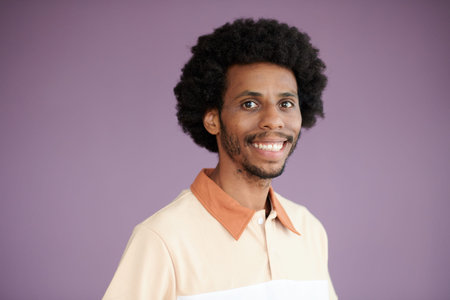 Studio portrait of excited Black man standing against lilac background and smiling at camera