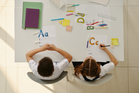Kids learning writing letters of English language alphabetの写真素材