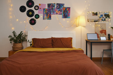 Decorated bedroom of teenager with string lights, placards and vinyl records on wallsの写真素材