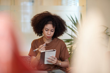 Portrait of woman writing plans and ideas in notebook