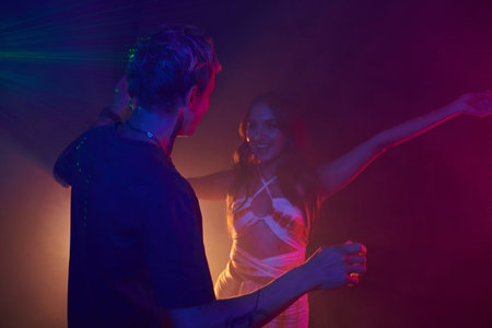 Young woman excited to meet friend in night club