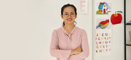 Header with smiling young Vietnamese school teacher standing in classの写真素材