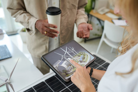 Sustainability engineer taking to investor and showing him project presentation