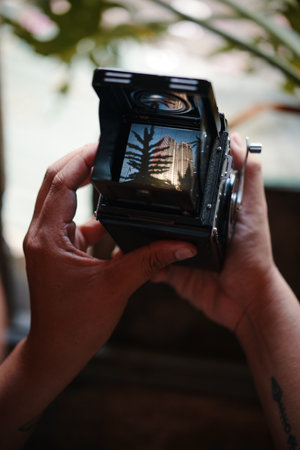 Closeup image of photographer checking photos he made on analog cameraの写真素材