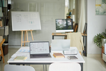 Office of small startup company with laptops and planner on desksの写真素材