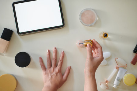 Hands of woman watching videos on tablet computer when doing manicure at home, top viewの写真素材