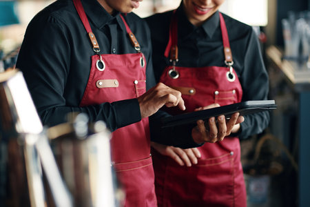 Cropped image of waiters checking new restaurant menu on tablet computerの写真素材