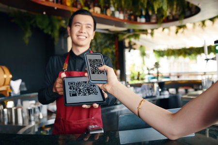 Restaurant guest scanning qr code when paying for orderの写真素材