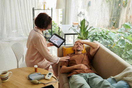 Wife caring about sick husband calling family doctor to ask for treatmentの写真素材