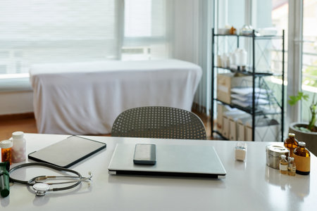 Smartphone, tablet and laptop on desk of physician in clinicの写真素材