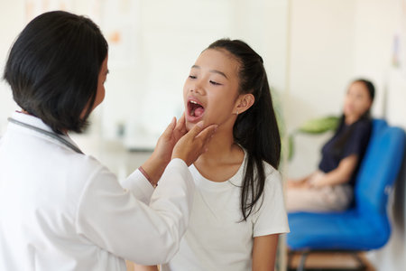 Pediatrician asking girl to open mouth when checking her throat