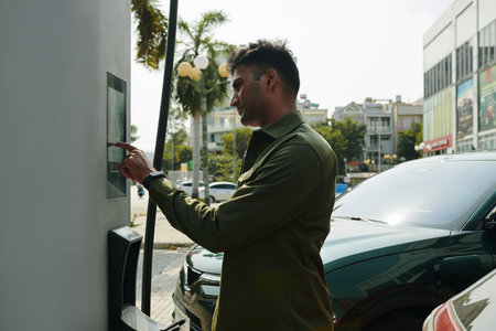 Electric car owner paying for charging