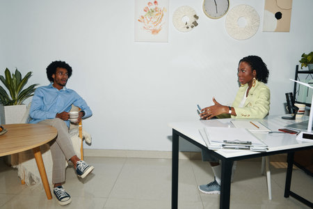 Black office managers discussing fresh ideas for company developments