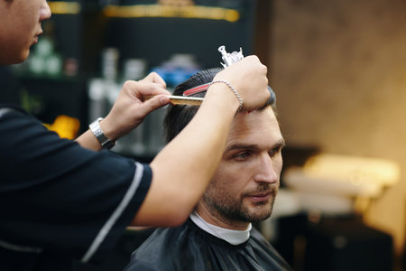 Barber combing and trimming top of the clients hairの写真素材
