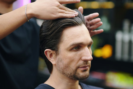 Man having his hair styled in barbershopの写真素材