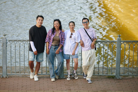 Group posing casually by the riverside fence, displaying friendship