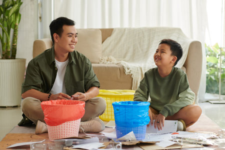 Cheerful father and son learning sorting waste