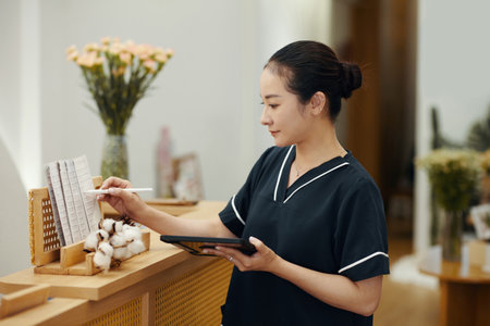 Spa salon manager checking price list and procedure descriptionの写真素材