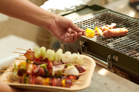 Closeup image of woman grilling food for party guestsの写真素材