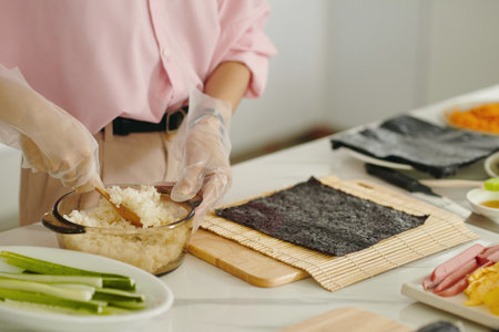 Woman Putting Rice On Nori To Make Sushiの写真素材