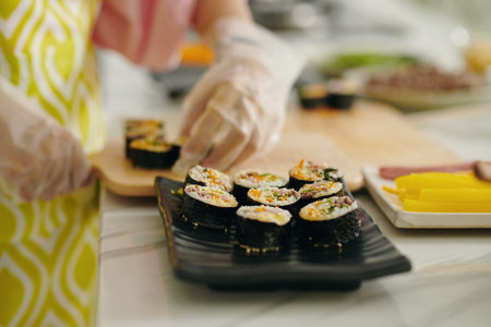 Woman Putting Kimbap On Dishの写真素材