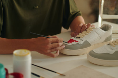 Designer Painting Custom Sneakers At Table