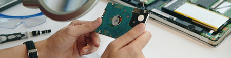 Repairman Examining Computer Disk At Workplace